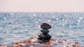 Balanced pebble pyramid on the beach on a sunny day. Abstract Sea bokeh on the background. Selective focus. Zen stones Royalty Free Stock Photo