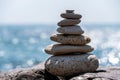 Balanced pebble pyramid on the beach on a sunny day. Abstract Sea bokeh on the background. Selective focus. Zen stones Royalty Free Stock Photo