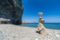 Balanced Pebbles Pyramid on the isolated Beach on Sunny Day and Clear Sky. Blue Sea on Background. Selective focus, Bokeh. Zen Royalty Free Stock Photo