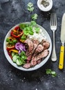 Balanced power buddha bowl - grilled beef steak, roasted and fresh vegetables, rice on a dark background, top view. Healthy diet Royalty Free Stock Photo