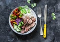 Balanced power buddha bowl - grilled beef steak, roasted and fresh vegetables, rice on a dark background, top view. Healthy diet