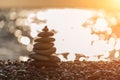 Balanced rock pyramid on pebbles beach. Golden sea bokeh on background. Selective focus, zen stones on sea beach Royalty Free Stock Photo
