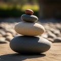 A balanced stack of four smooth stones is shown, each varying in size and color. The largest stone Royalty Free Stock Photo