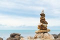 Balanced stone pyramid on green water of ocean.