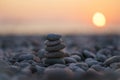 Balanced stone pyramid on pabbles beach with sunset. Zen rock, concept of balance and harmony Royalty Free Stock Photo