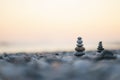 Balanced stone pyramid on pabbles beach with sunset. Zen rock, concept of balance and harmony Royalty Free Stock Photo