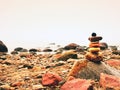 Balanced stone pyramid on sea shore, waves in background. Colorful flat stones Royalty Free Stock Photo