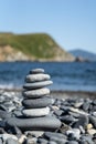 Balanced stone pyramide on the beach with black and grey stones