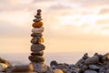 Balanced stone pyramide on shore of the ocean at dawn. Sea pebbles tower closeup symbolizing stability, zen, harmony Royalty Free Stock Photo