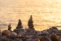 Balanced stone pyramide on shore of the ocean at dawn. Sea pebbles tower closeup symbolizing stability, zen, harmony Royalty Free Stock Photo