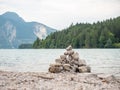 Balanced stones stacked in pyramid at lake water with Dolomite Alps reflection Royalty Free Stock Photo