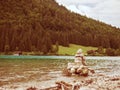 Balanced stones stacked in pyramid at lake water with Dolomite Alps reflection Royalty Free Stock Photo