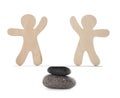 Balancing wooden human figures on stones against white background