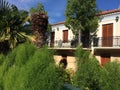 The balconies of the house are hidden in the trees. Little orange villa in a hidden garden