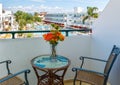 Balcony with chairs and table overlooking swimming pool at luxury tropical hotel resort Royalty Free Stock Photo