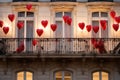 A balcony covered in numerous red hearts, providing a joyful and charming scene, Heart balloons tethered on Parisian balconies