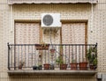 Balcony with flowers in pots, curtains and an AC machine Royalty Free Stock Photo