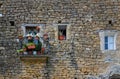 Old stone wall with a small balcony decorated with flowerpots. Royalty Free Stock Photo