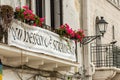 Balcony with flowers, street lamp and a banner (Here no-one is a foreigner) in Bari old town