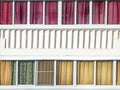 Balcony glazing with colourful textile curtains and architectural elements on a sunny day