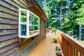 Balcony house exterior with wooden trim and flowers pots.