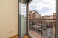 Balcony of a house with metal railing with grid and window in gray