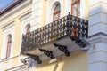 A balcony with an openwork wrought-iron parapet at the street in