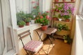 Balcony with small table, chair and flowers. Royalty Free Stock Photo