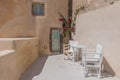 Balcony with two chairs. and minimalist flowers. Santorini, Greece.