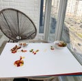 Balcony veranda. wicker chair, gray. against the background of a table with a white base. gummy bears on the table. panoramic