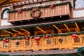 Balcony of Wooden Vintage Restaurant Building Decorated of Artificial Fir Tree with Lighting Garland and many Red Christmas Balls Royalty Free Stock Photo