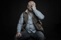 A bald adult man holds his head in his hands. Depression and financial problems in a crisis. Unemployment during the coronavirus Royalty Free Stock Photo