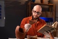 Bald archaeologist in glasses studying an ancient artifact reading a book working late in the office