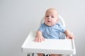 bald baby boy 3 months sitting in baby chair on white background Royalty Free Stock Photo