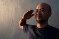 Bald beard 40s Japanese portrait man with salute hand with blue concrete wall background