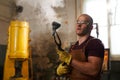 Bald blacksmith checking metal piece after quenching