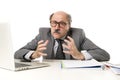 Bald business man 60s working stressed and frustrated at office computer laptop desk looking tired Royalty Free Stock Photo