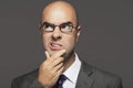 Bald Businessman With Hand On Chin Making Funny Face Royalty Free Stock Photo