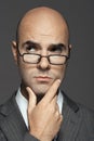 Bald Businessman Wearing Glasses With Hand On Chin