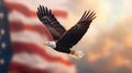 A bald eagle soars high in front of a blurred American flag background as the sun sets. Royalty Free Stock Photo