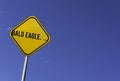 bald eagle. ... - yellow sign with blue sky background