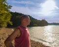 Bald elderly man on the beach under the scorching sun..