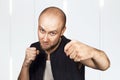 Bald evil guy criminal extortionist preparing for a fight and swinging his fist Royalty Free Stock Photo