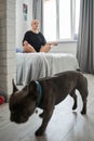 Bald girl meditating in cozy room while sitting at the bed