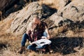 Bald guy with a beard and a blonde girl are looking at the map and looking for Royalty Free Stock Photo