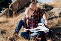 Bald guy with a beard and a blonde girl are looking at the map and looking for Royalty Free Stock Photo