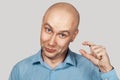 A bald guy shows a hand gesture meaning a very small amount of something Royalty Free Stock Photo