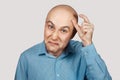 A bald guy shows a hand gesture meaning a very small amount of something Royalty Free Stock Photo
