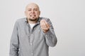 Bald handsome bearded man looking angry showing italian gesture over white background. Private businessman is annoyed