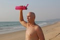 A bald, handsome man with a naked or bare torso watering himself Royalty Free Stock Photo